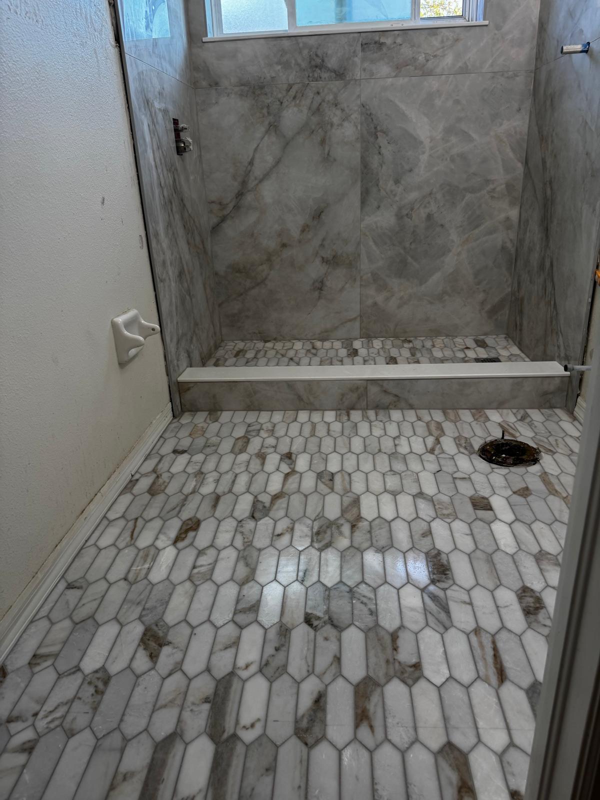 Marble-look hexagon tile floor and shower surround — same bathroom project as the finished glass shower