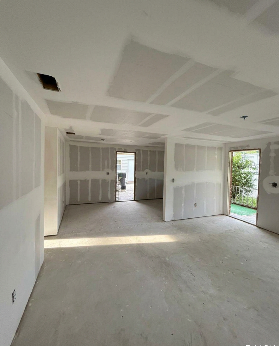 Drywall installed and taped in an open living area