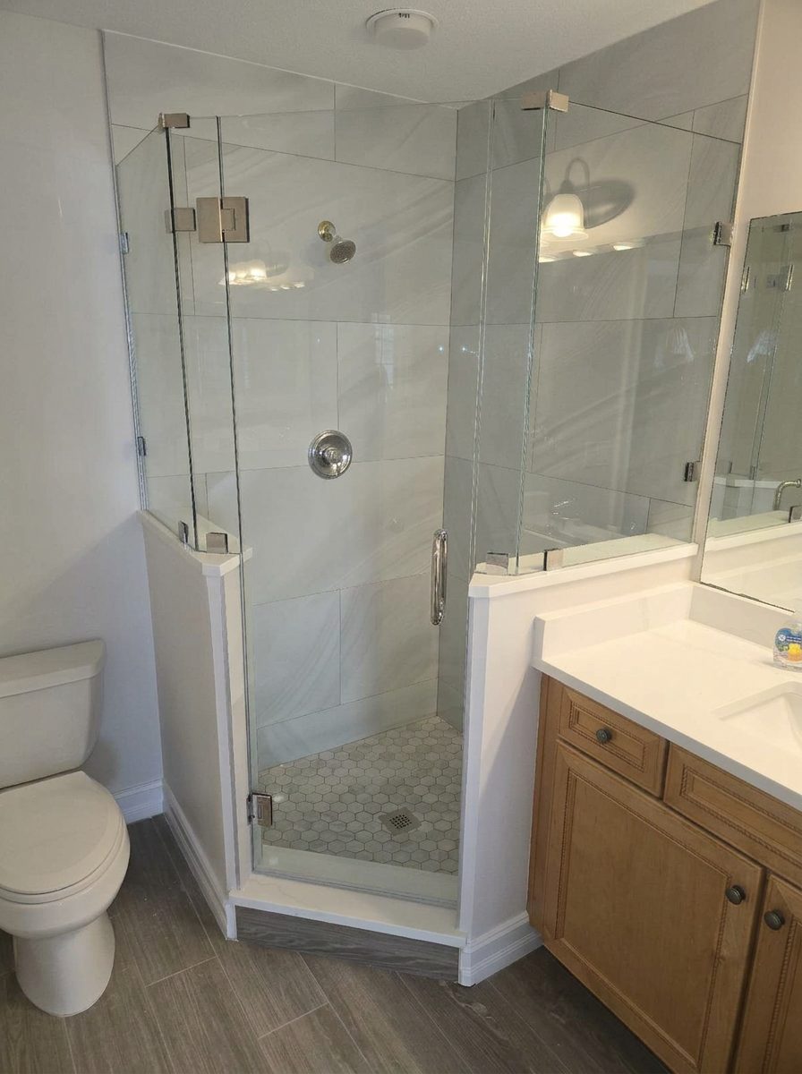 Finished bathroom remodel with frameless glass corner shower and vanity