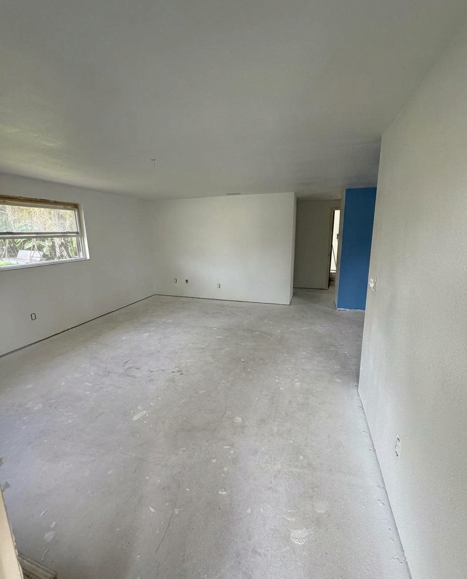 Room stripped to bare concrete with old insulation removed during repair work